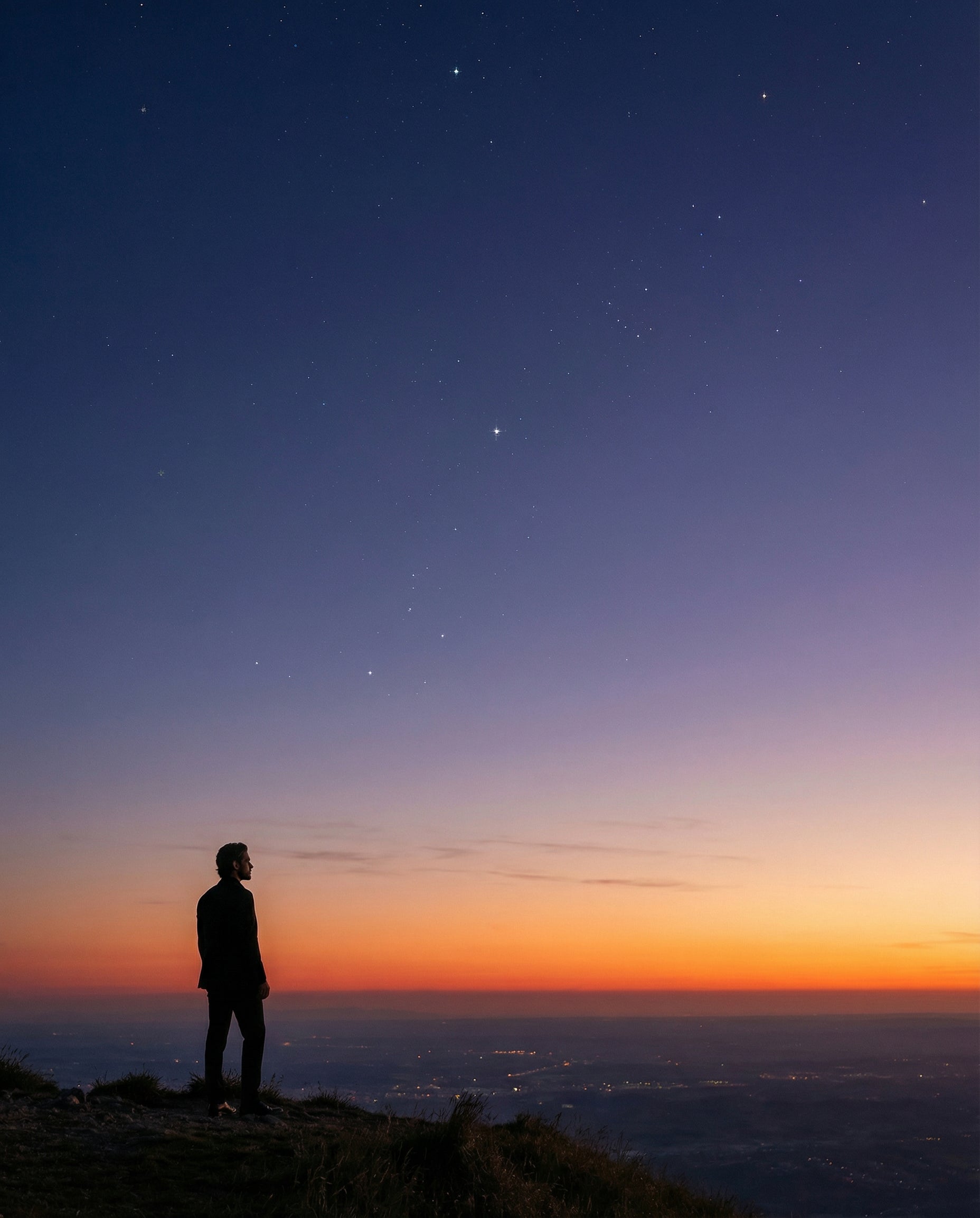 A modern explorer standing on a mountain at sunset, looking toward a starry sky, symbolizing ambition, discovery and the cosmic inspiration behind ROY VIROK.