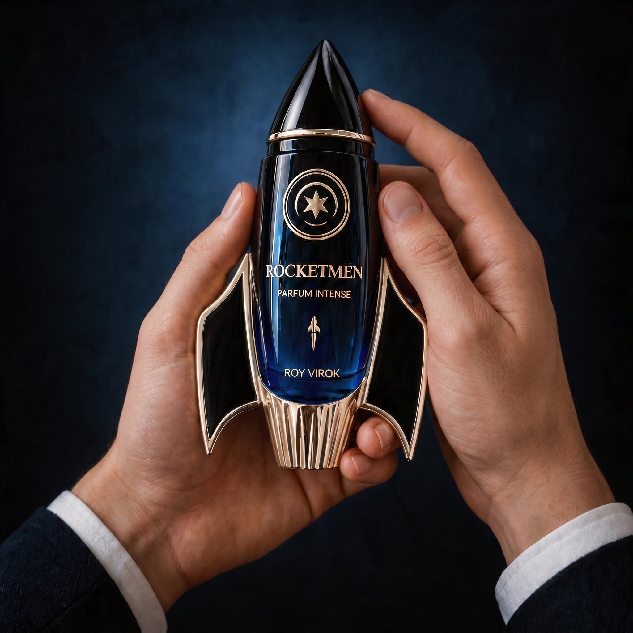 Frasco ROY VIROK ROCKETMEN Parfum Intense sostenido entre manos masculinas elegantes, con diseño de cohete, vidrio azul profundo y detalles dorados.